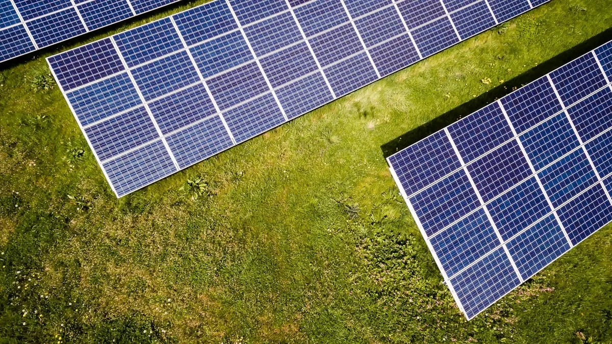 Aerial view of a ground-mounted commercial solar panel array on grass